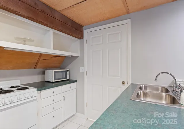 a kitchen with white cabinets and sink
