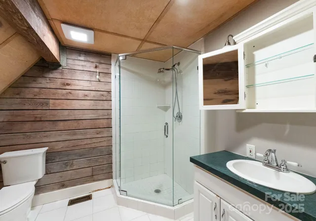 a bathroom with a granite countertop sink mirror and shower