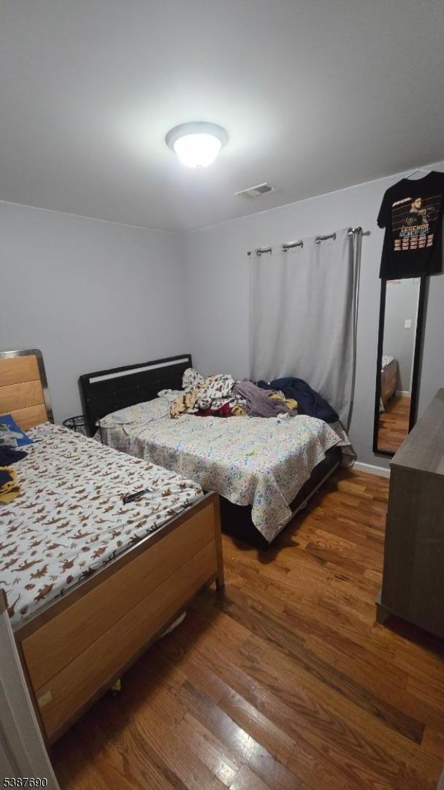 21 Rose Street Paterson, NJ 07501 - Photo 24 of 28 a bedroom with a bed and wooden floor