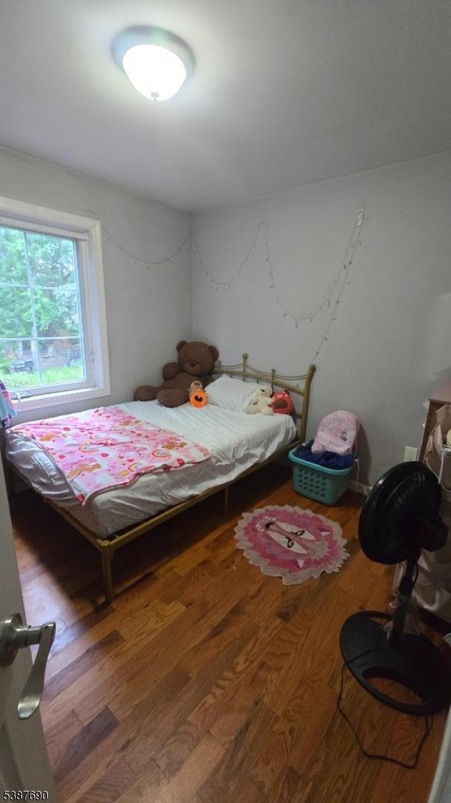 21 Rose Street Paterson, NJ 07501 - Photo 9 of 28 a bedroom with a bed and a wooden floor