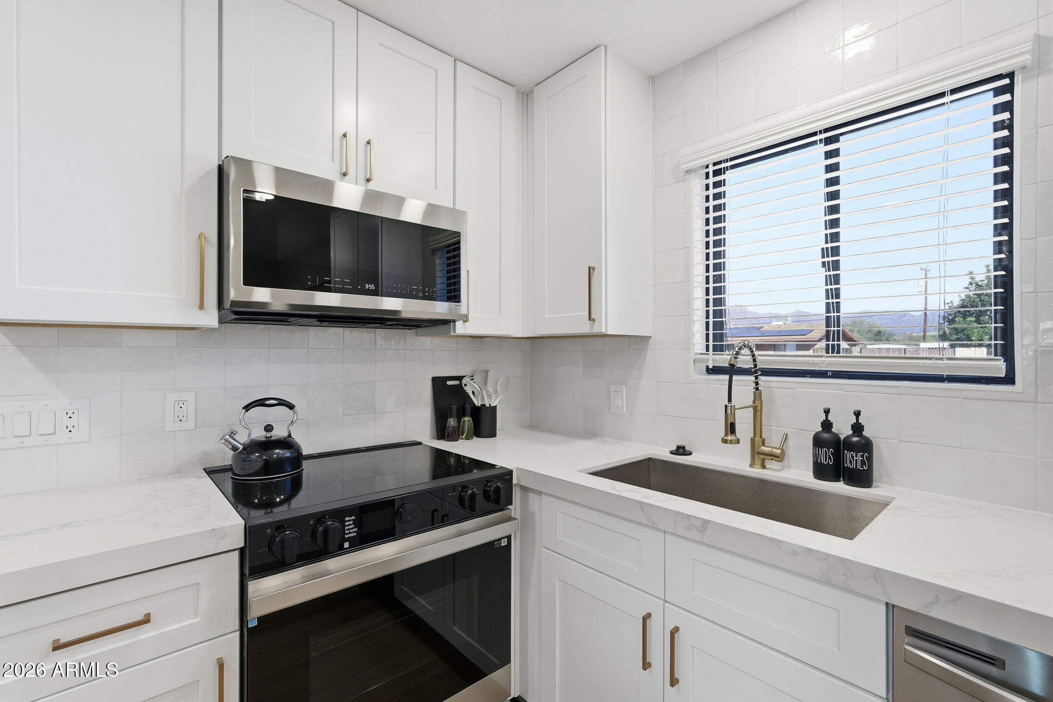 1336 South Cactus Road Apache Junction, AZ 85119 - Photo 11 of 37 a kitchen with stainless steel appliances white cabinets and a stove top oven