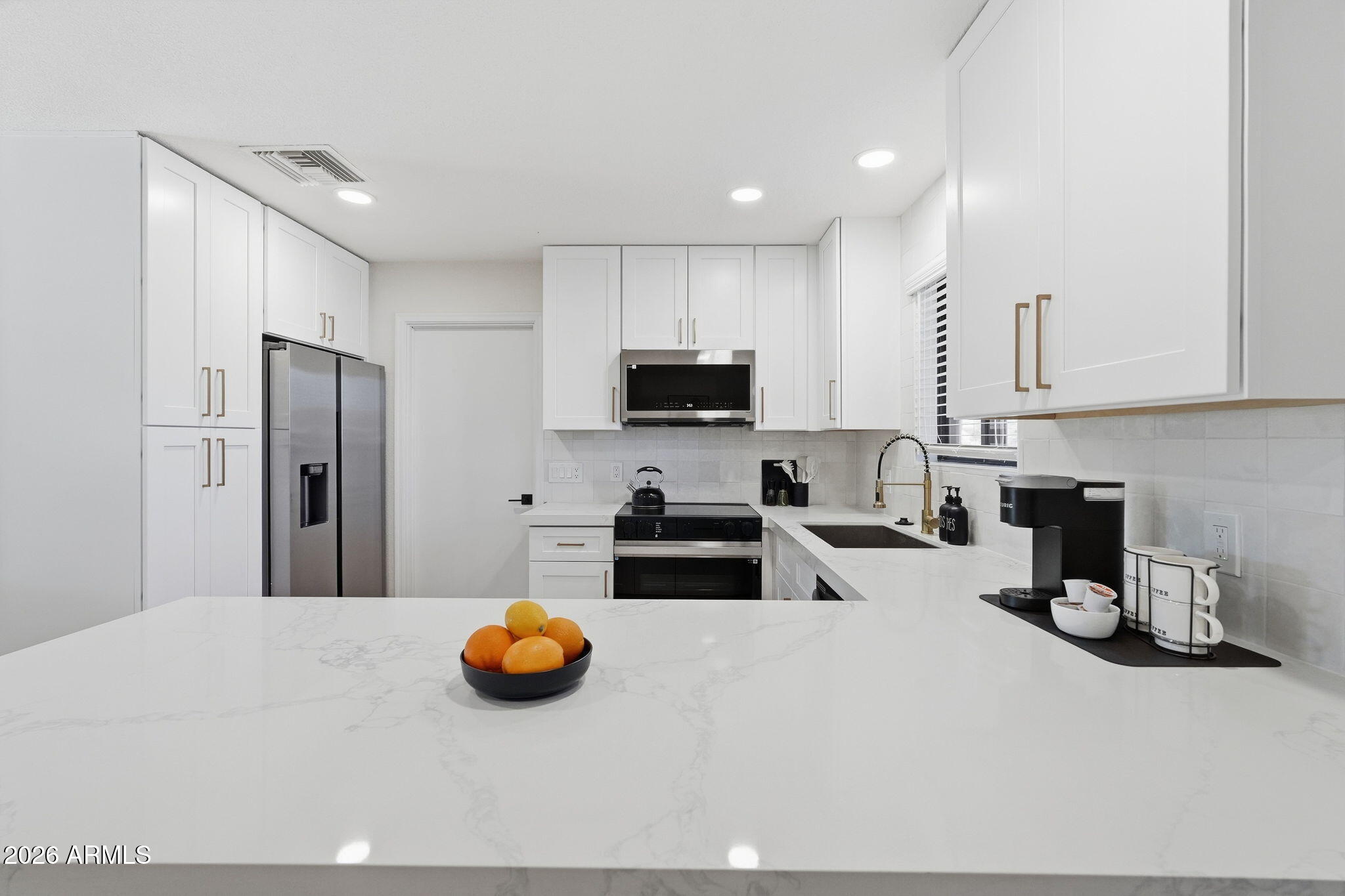 1336 South Cactus Road Apache Junction, AZ 85119 - Photo 13 of 37 a kitchen with a refrigerator and a stove top oven