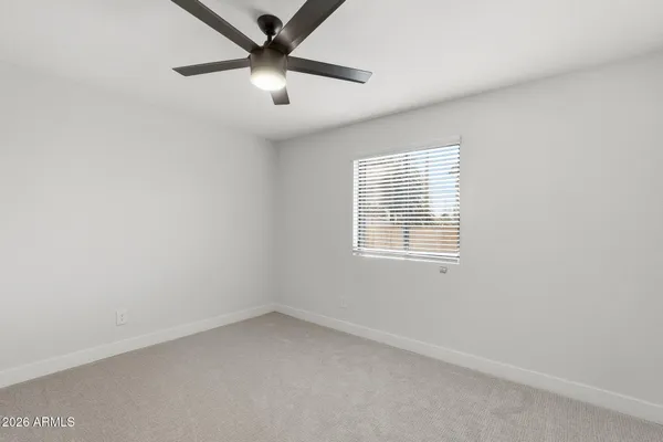 an empty room with a window and a fan