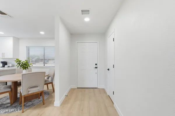 a view of a hallway to dining room with furniture and wooden floor