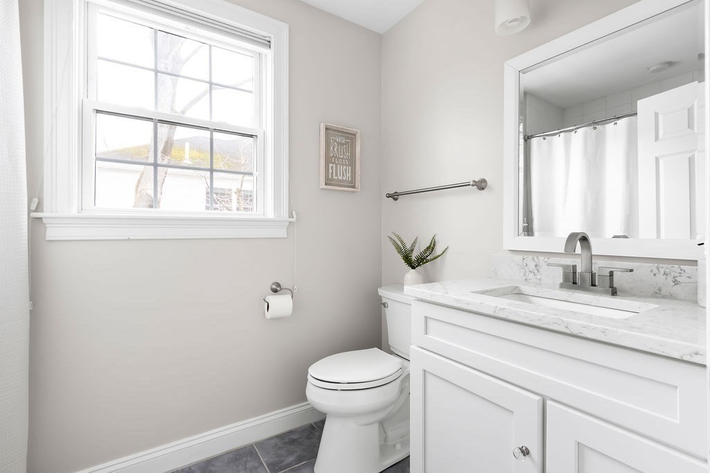 7 Maple Place Needham, MA 02492 - Photo 16 of 26 a bathroom with a granite countertop toilet sink and mirror