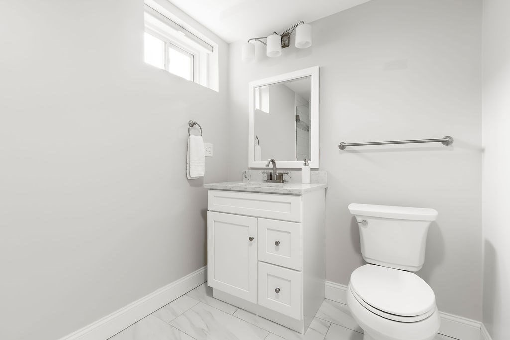 7 Maple Place Needham, MA 02492 - Photo 19 of 26 a bathroom with a toilet a sink a vanity and mirror