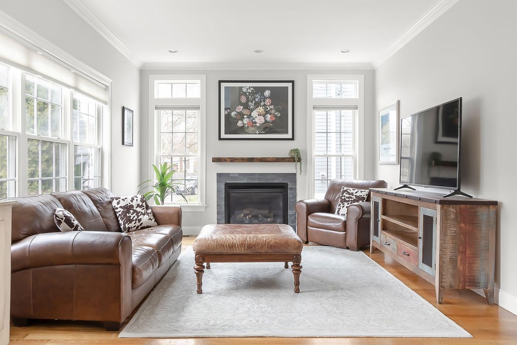 7 Maple Place Needham, MA 02492 - Photo 3 of 26 a living room with furniture a flat screen tv and a fireplace