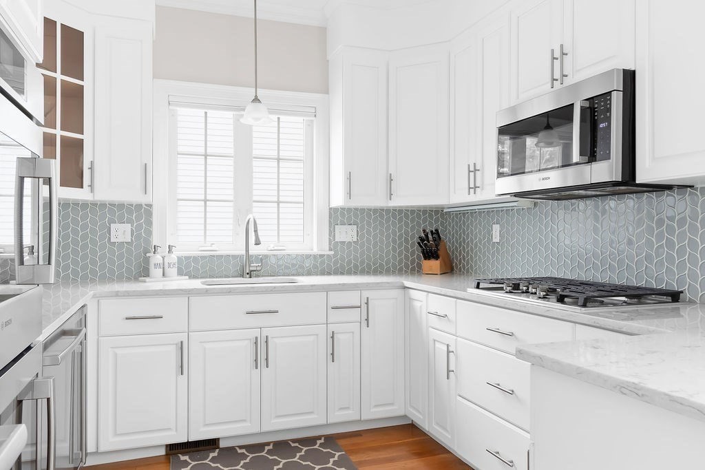 7 Maple Place Needham, MA 02492 - Photo 6 of 26 a kitchen with granite countertop white cabinets and white appliances