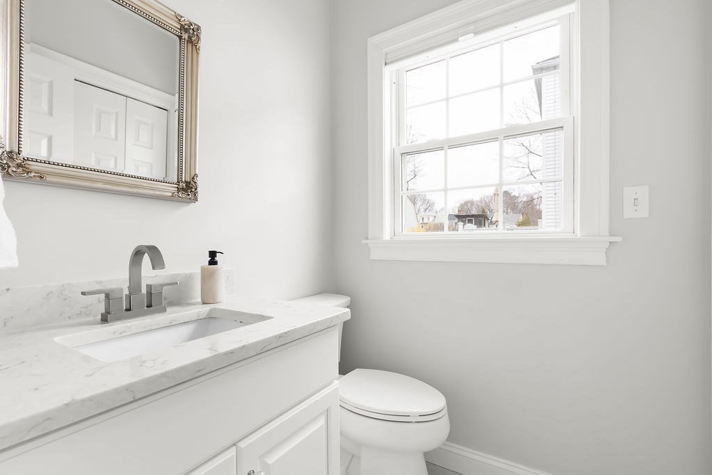 7 Maple Place Needham, MA 02492 - Photo 9 of 26 a bathroom with a toilet sink vanity and mirror