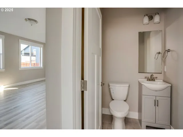 a open kitchen with white cabinets and wooden floor
