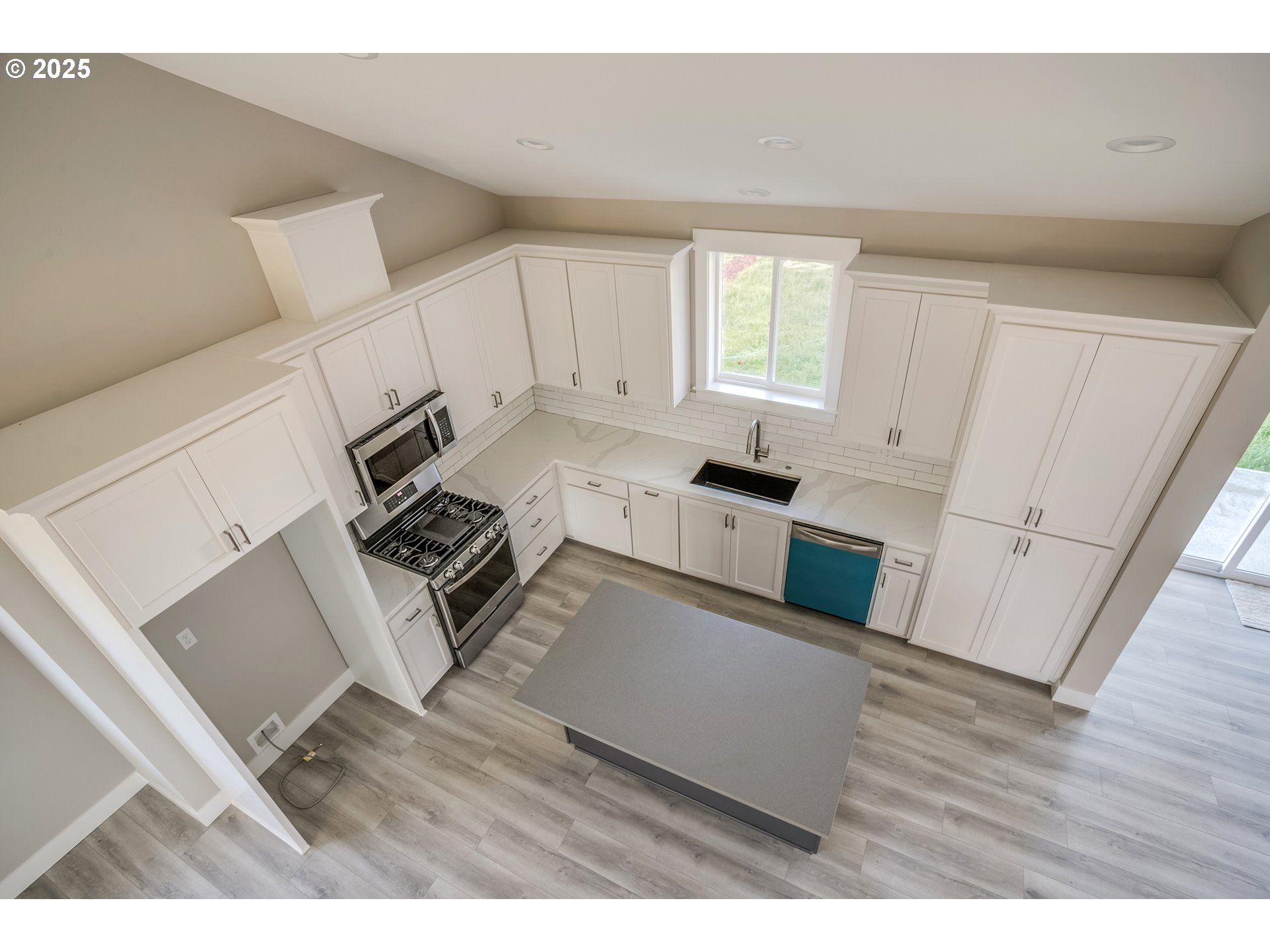 790 17th Avenue Seaside, OR 97138 - Photo 12 of 29 a open kitchen with white cabinets and wooden floor
