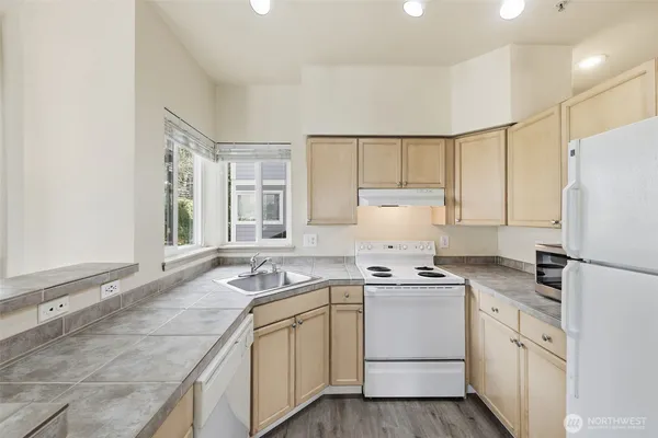 a kitchen that has a sink cabinets counter space and appliances
