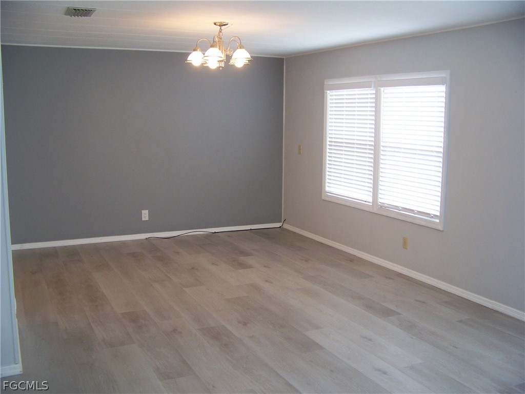 15550 Burnt Store Road, Unit 202 Punta Gorda, FL 33955 - Photo 22 of 50 wooden floor in an empty room with a window