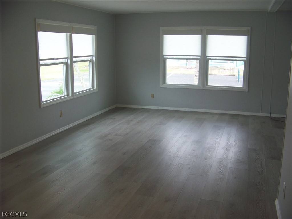 15550 Burnt Store Road, Unit 202 Punta Gorda, FL 33955 - Photo 23 of 50 an empty room with wooden floor and windows