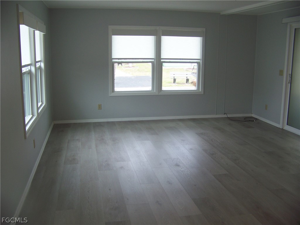 15550 Burnt Store Road, Unit 202 Punta Gorda, FL 33955 - Photo 24 of 50 an empty room with wooden floor and windows