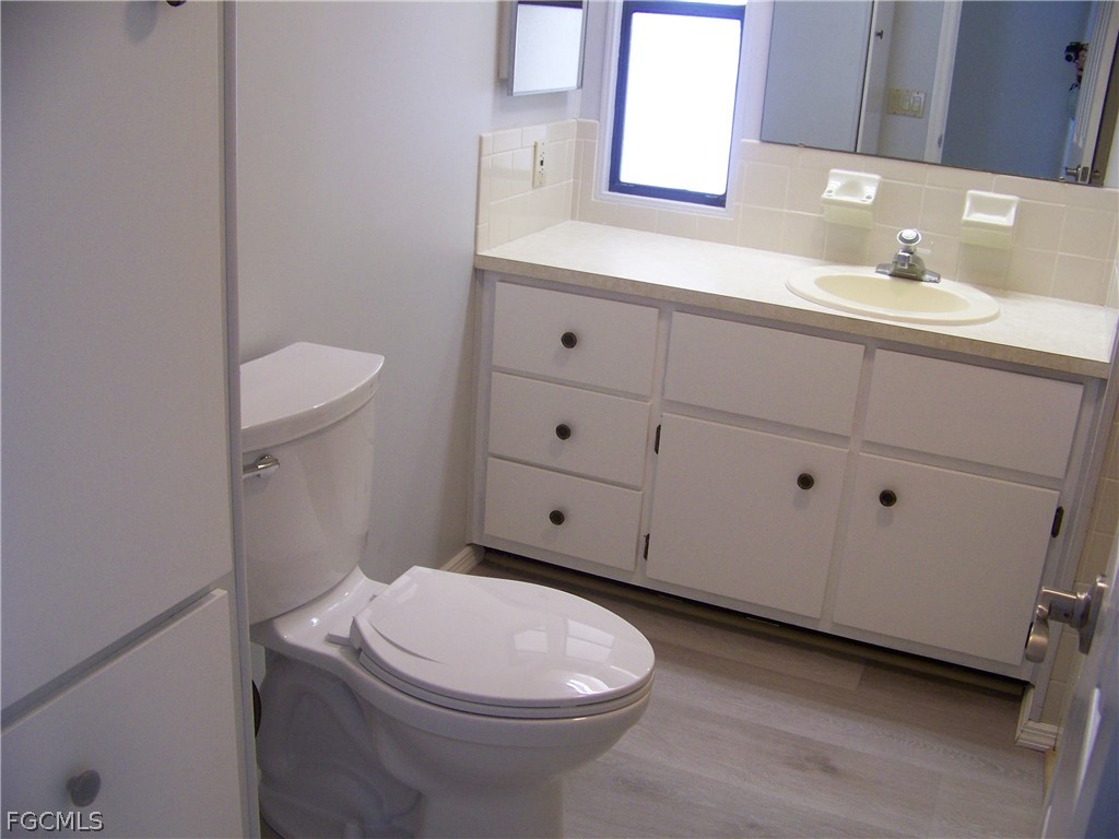 15550 Burnt Store Road, Unit 202 Punta Gorda, FL 33955 - Photo 28 of 50 a bathroom with a sink a toilet and mirror