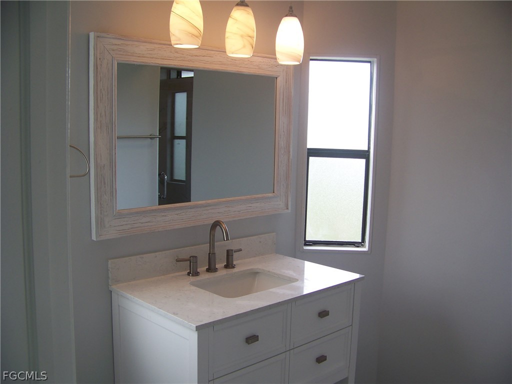 15550 Burnt Store Road, Unit 202 Punta Gorda, FL 33955 - Photo 36 of 50 a bathroom with a sink and a mirror