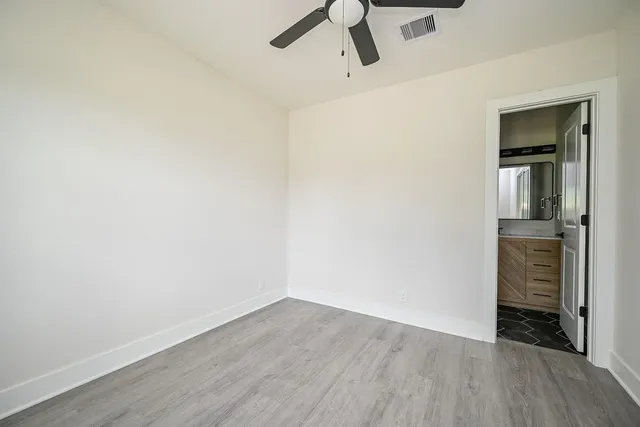 a view of a room with wooden floor and a ceiling fan