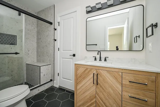 a bathroom with a sink a toilet and shower