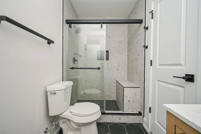 a bathroom with a toilet and a shower