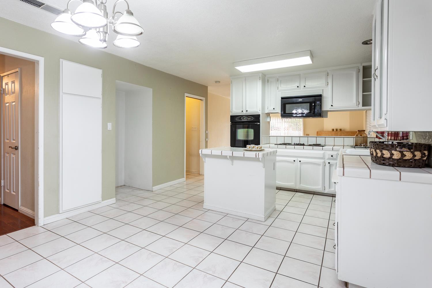1505 Bandera Lane Modesto, CA 95355 - Photo 16 of 35 a kitchen with white cabinets a sink dishwasher and a stove with wooden floor