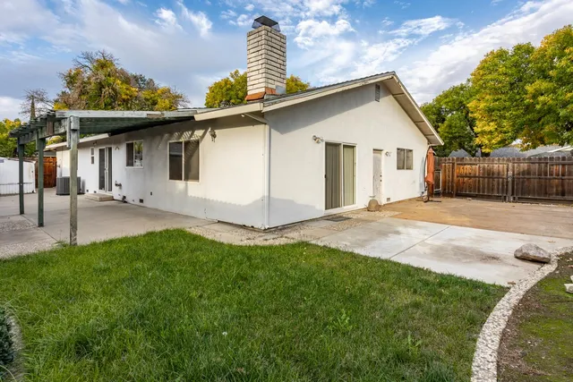 a view of backyard with potted plants and wooden fence