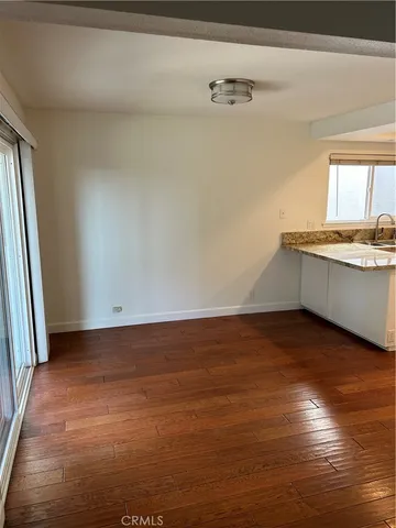 a view of a kitchen with wooden floor and a sink
