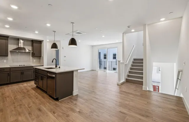 a kitchen with stainless steel appliances kitchen island granite countertop a refrigerator a sink and a stove