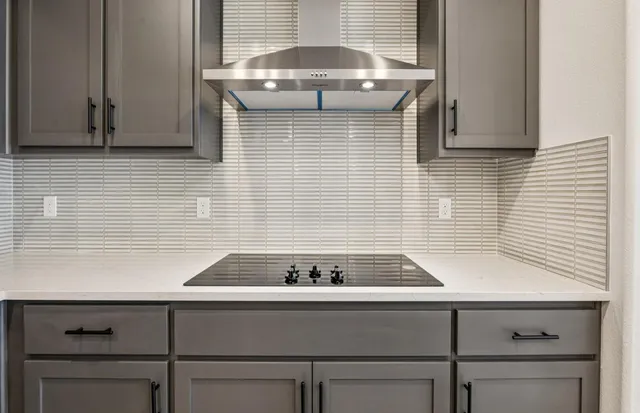 a kitchen with stainless steel appliances white cabinets and a wooden floor