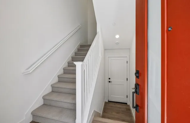 a view of a hallway with wooden floor and staircase