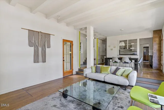 a view of a hallway with wooden floor and windows
