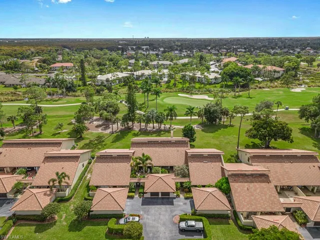 an aerial view of residential houses with outdoor space and parking