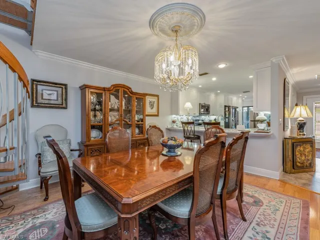 a view of a dining room with furniture a chandelier and wooden floor