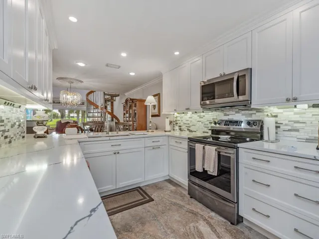 a kitchen with stainless steel appliances granite countertop a stove a sink and a microwave