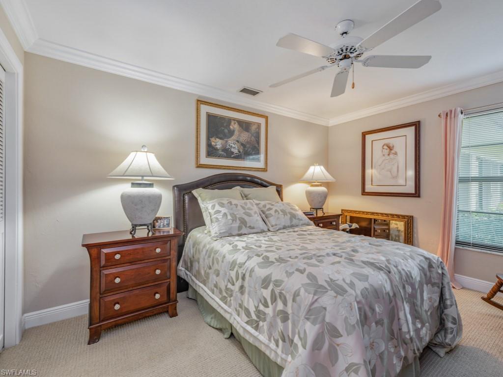 594 Augusta Boulevard, Unit 3 Naples, FL 34113 - Photo 10 of 20 a bedroom with a bed and a lamp on dresser