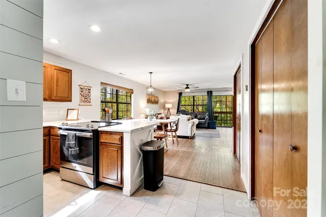 a kitchen with a sink a refrigerator and chairs