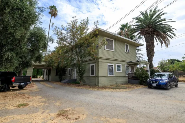 a car parked in front of house with a yard