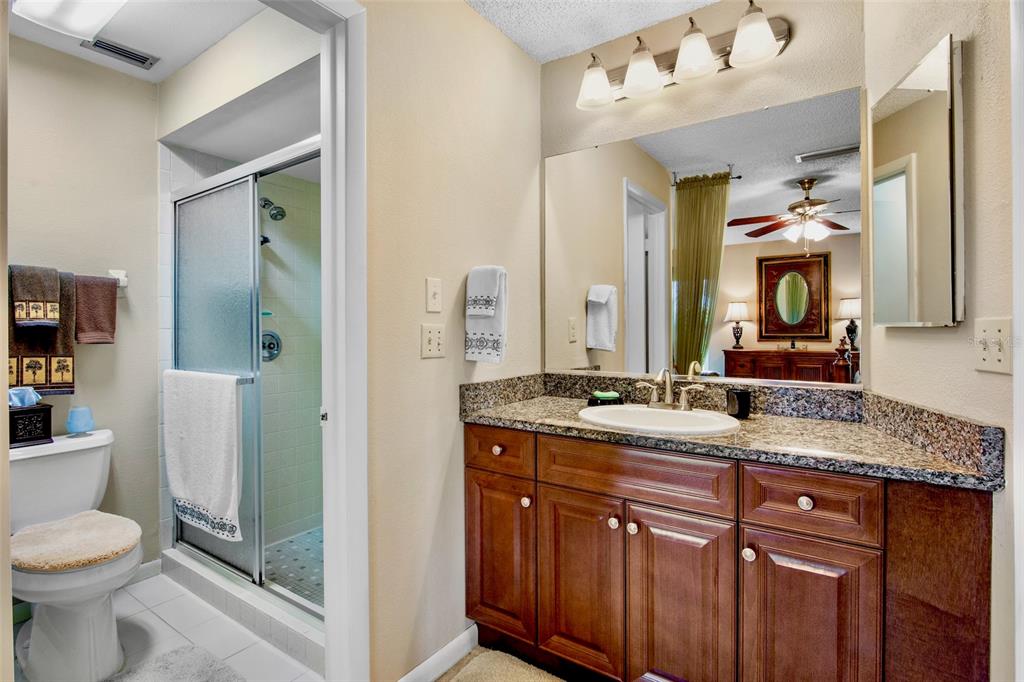 3905 Center Gate Circle, Unit 3 Sarasota, FL 34233 - Photo 16 of 20 a bathroom with a granite countertop sink mirror and toilet