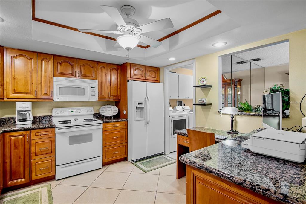 3905 Center Gate Circle, Unit 3 Sarasota, FL 34233 - Photo 5 of 20 a kitchen with stainless steel appliances granite countertop a stove refrigerator and cabinets