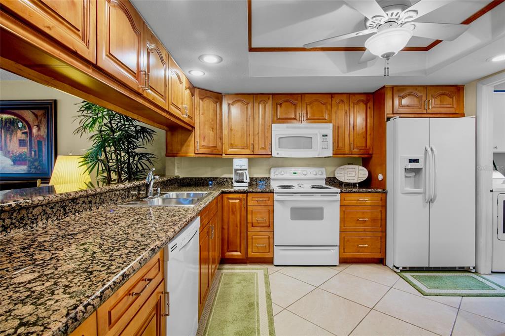 3905 Center Gate Circle, Unit 3 Sarasota, FL 34233 - Photo 6 of 20 a kitchen with stainless steel appliances granite countertop a sink a stove and a refrigerator