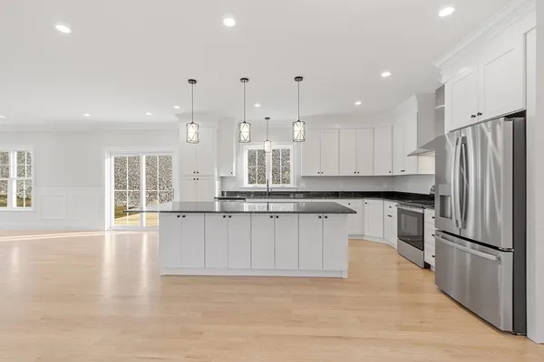 a large kitchen with stainless steel appliances granite countertop a sink a stove and a refrigerator