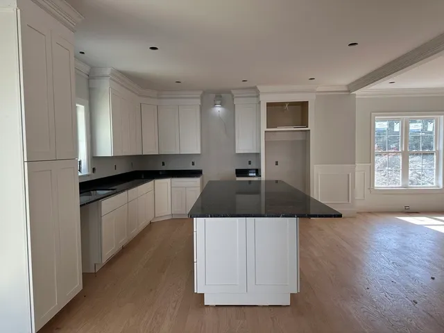a kitchen with stainless steel appliances granite countertop a sink and white cabinets