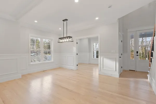 a view of empty room with wooden floor and entryway