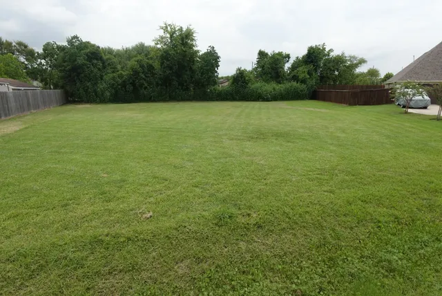 a view of a field with an trees in the background