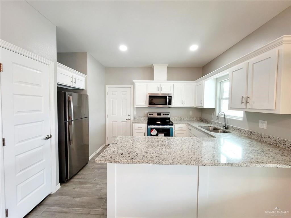 2109 Stauffer Street, Unit 4 Weslaco, TX 78596 - Photo 3 of 14 a kitchen with stainless steel appliances granite countertop a refrigerator a stove and a sink