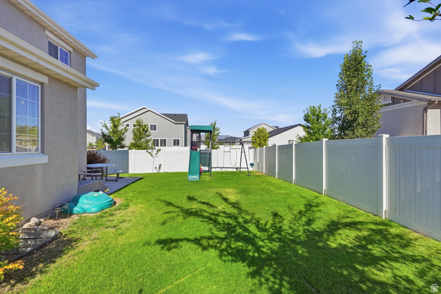 3244 West 1670th Street North Provo, UT 84601 - Photo 47 of 56 Expansive backyard featuring a lush lawn, white privacy fencing, and a concrete patio area