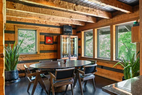 a dining hall with stainless steel appliances granite countertop a stove a refrigerator a dining table and chairs with wooden floor