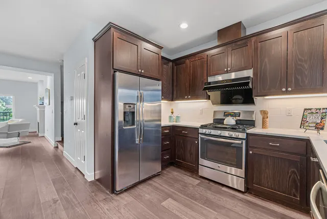 a kitchen with stainless steel appliances granite countertop a refrigerator stove and sink