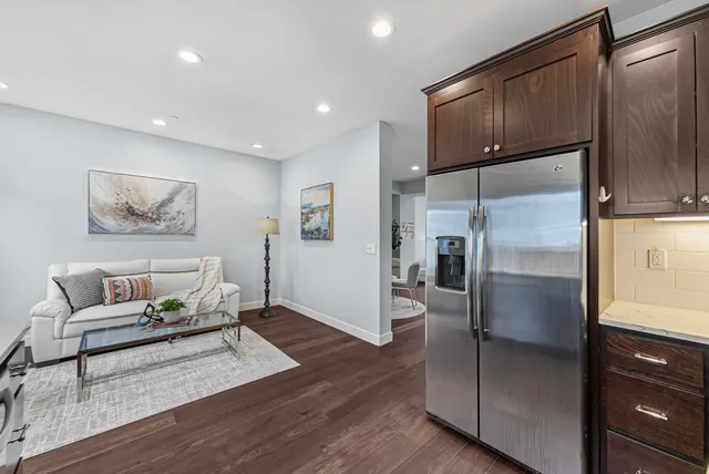 a kitchen with stainless steel appliances granite countertop a refrigerator a stove and a refrigerator with wooden floor