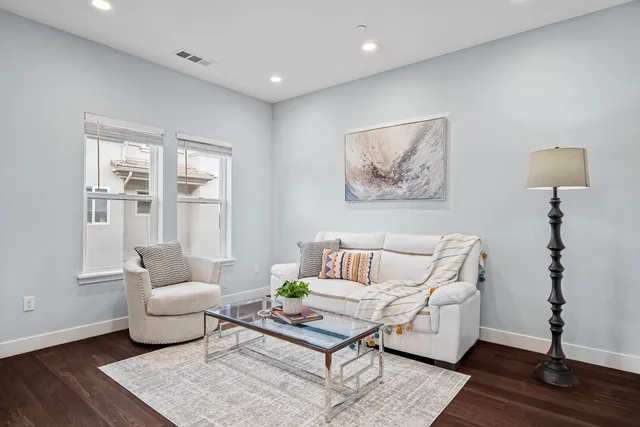 a living room with furniture and wooden floor
